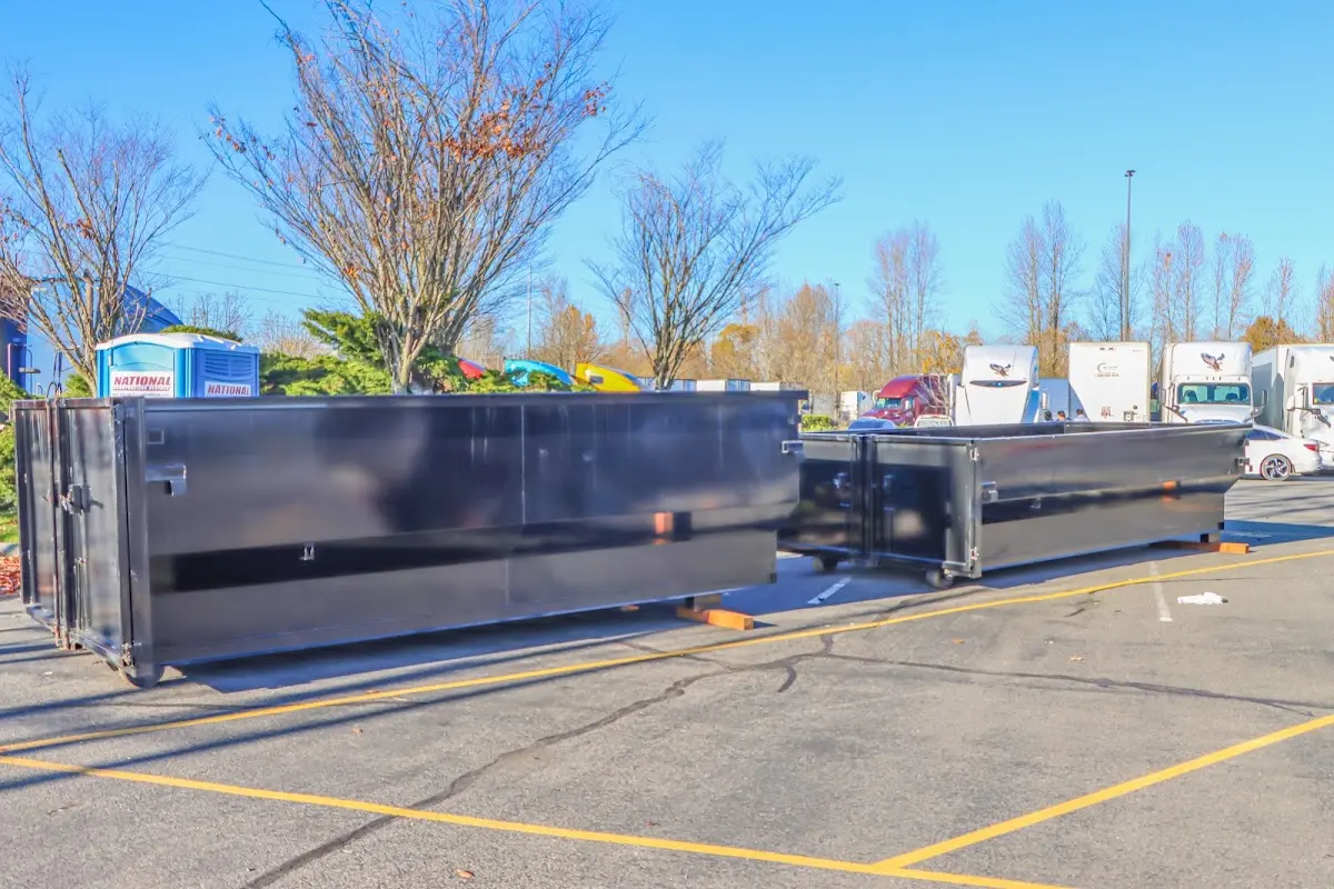 Professional dumpster rental service with roll-off container on residential driveway in Raymondville